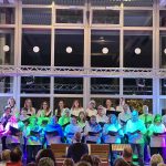 Ein Foto zeigt den PopChor des Sängerhains Grünwettersbach auf der Bühne beim Treffen moderner Chöre in Auerbach am 25.10.2025.